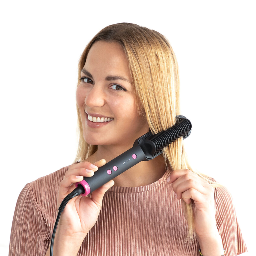 Femme blonde souriante passant la brosse lissante dans ses cheveux, sur fond blanc détouré